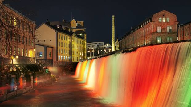 Ett vattenfall är upplyst i flera olika färger.