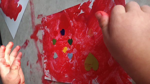 Ett förskolebarn skapar ett Alla hjärtans dag-kort