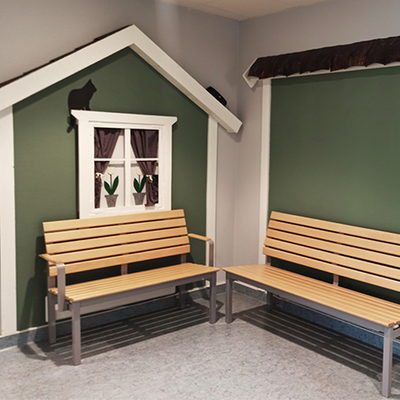 Ett rum med två bänkar och dekoration som liknar en liten stuga.